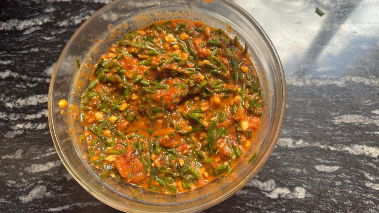 A bowl of managu greens cooked briefly in a tomato and onion sauce