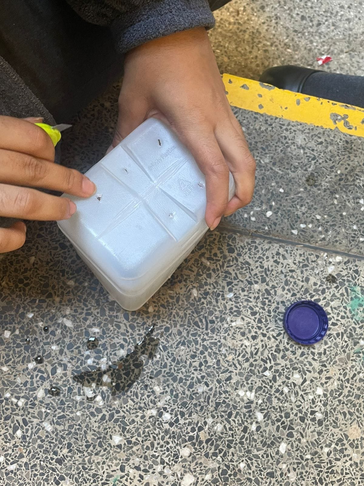 Drainage holes being made in the base of a bottle
